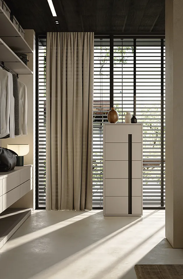Settimino Trace Colombini color sabbia con maniglia verticale nera accanto a una cabina armadio
