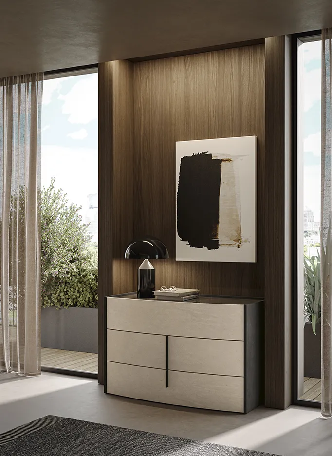 Comò Flow Colombini con frontali chiari curvi e cassa scura in una nicchia in legno