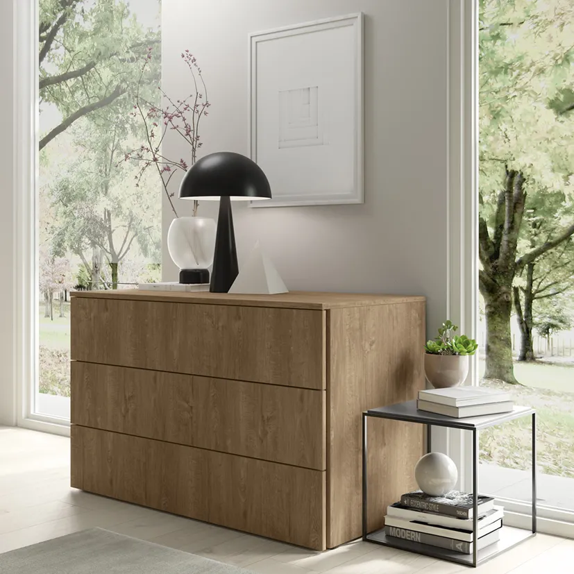 Comò Link Colombini in legno caldo davanti a una finestra con struttura metallica nera