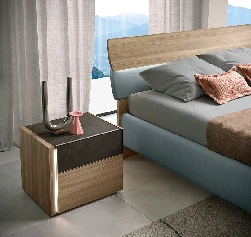 Comodino Notte di Stelle 20 Corso 11 in legno con cassetto in pietra scura accanto al letto