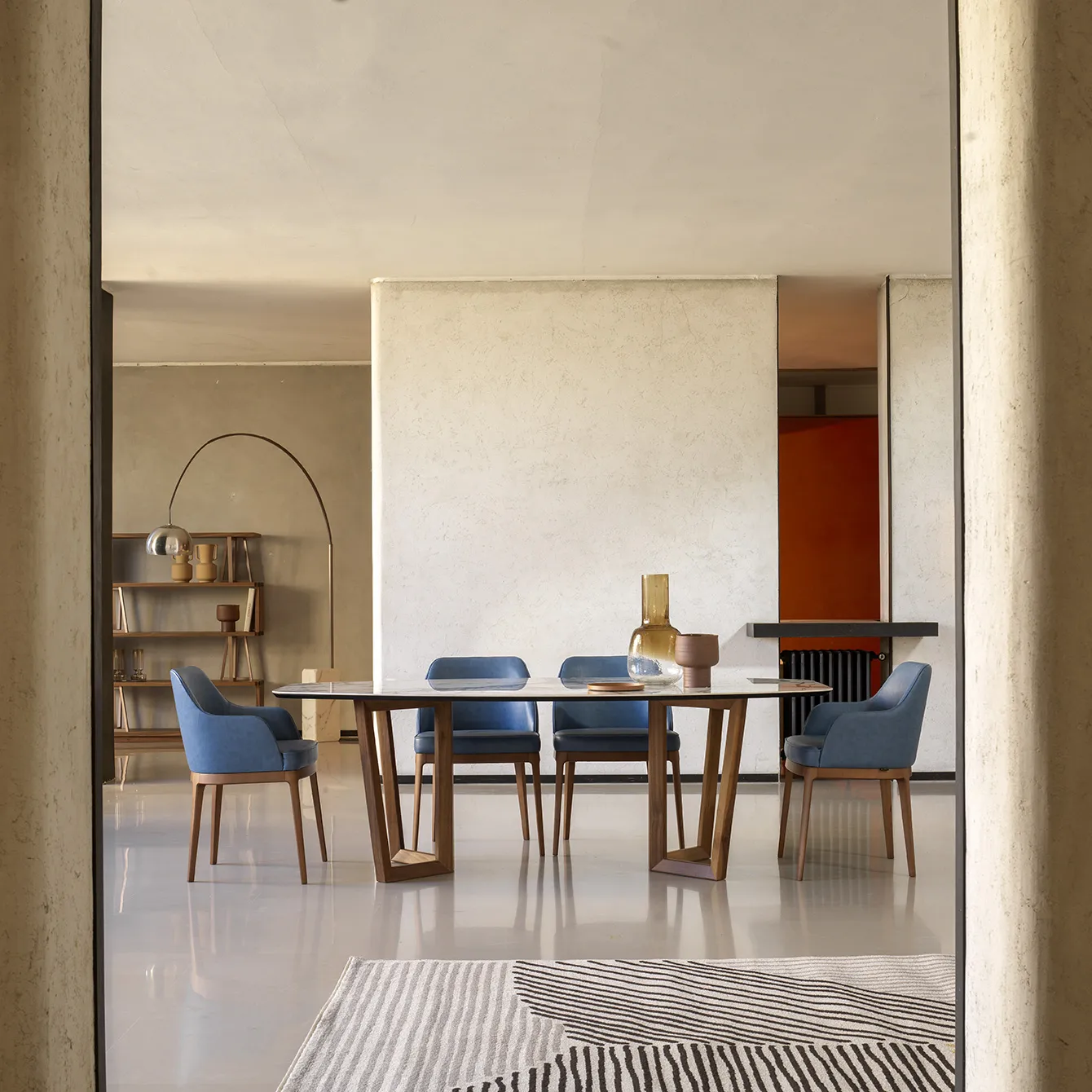 Zona pranzo con poltroncine Tosato 50.47 blu attorno a un tavolo in legno