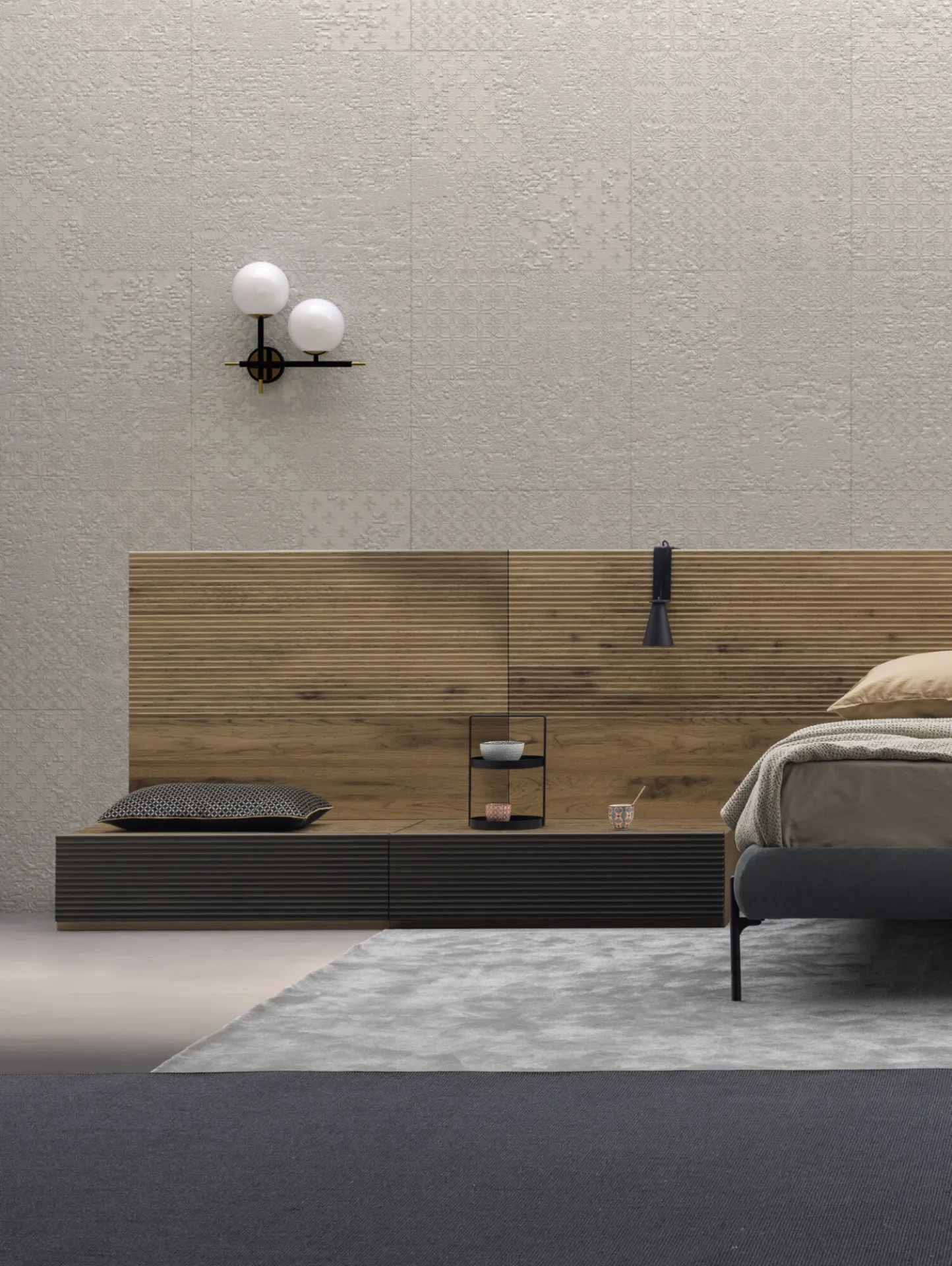 Comodini Brick Devina Nais a terra ai lati di un letto con testiera in rovere