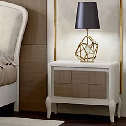 Comodino con facciata in rovere Ocean Francesco Pasi accanto al letto con lampada dorata