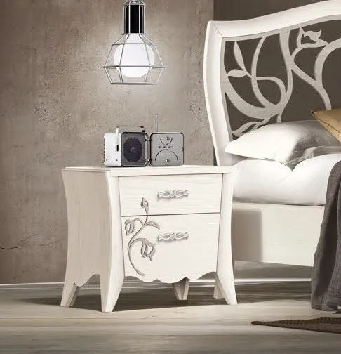 Comodino sagomato con decoro Trend Style Imba bianco accanto al letto traforato
