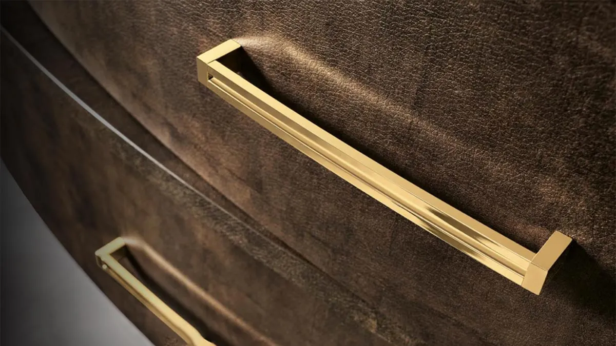 Dettaglio delle maniglie oro sulla finitura effetto pelle del comò Incanto Mobilpiù