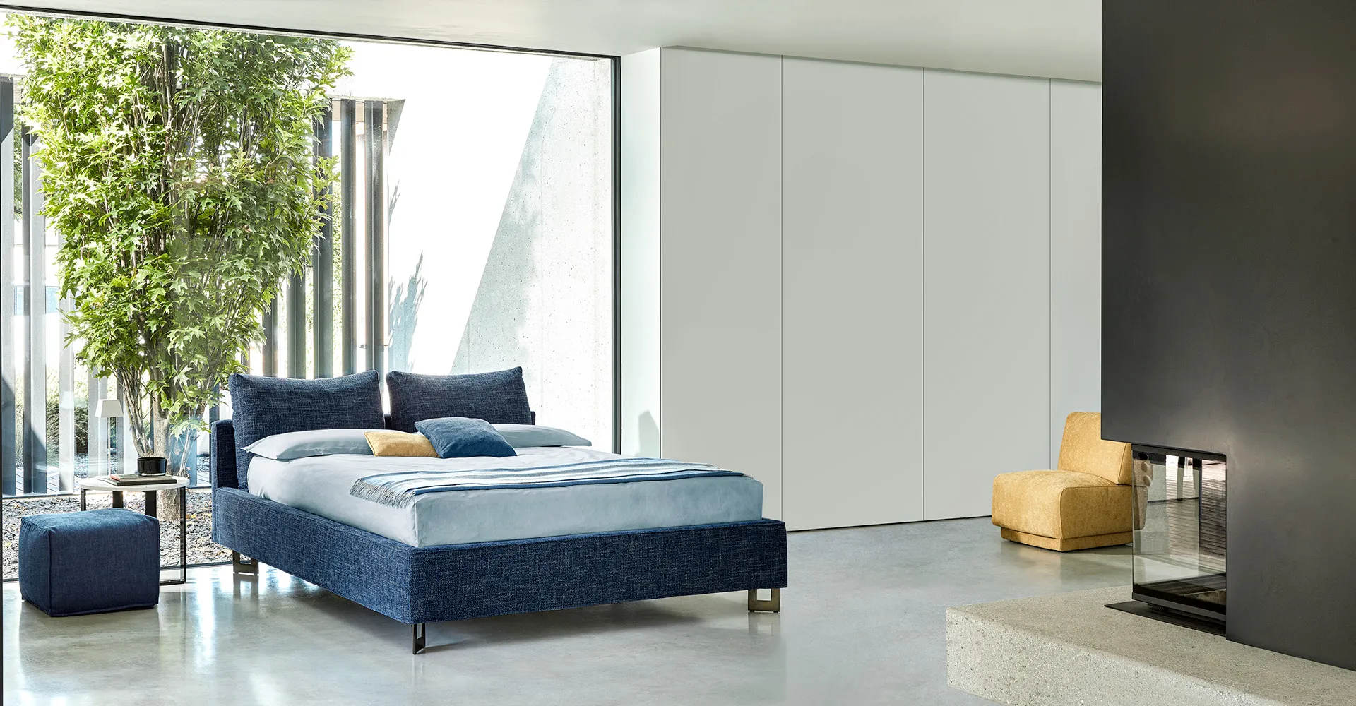 Letto Athena Rosini blu in una camera luminosa