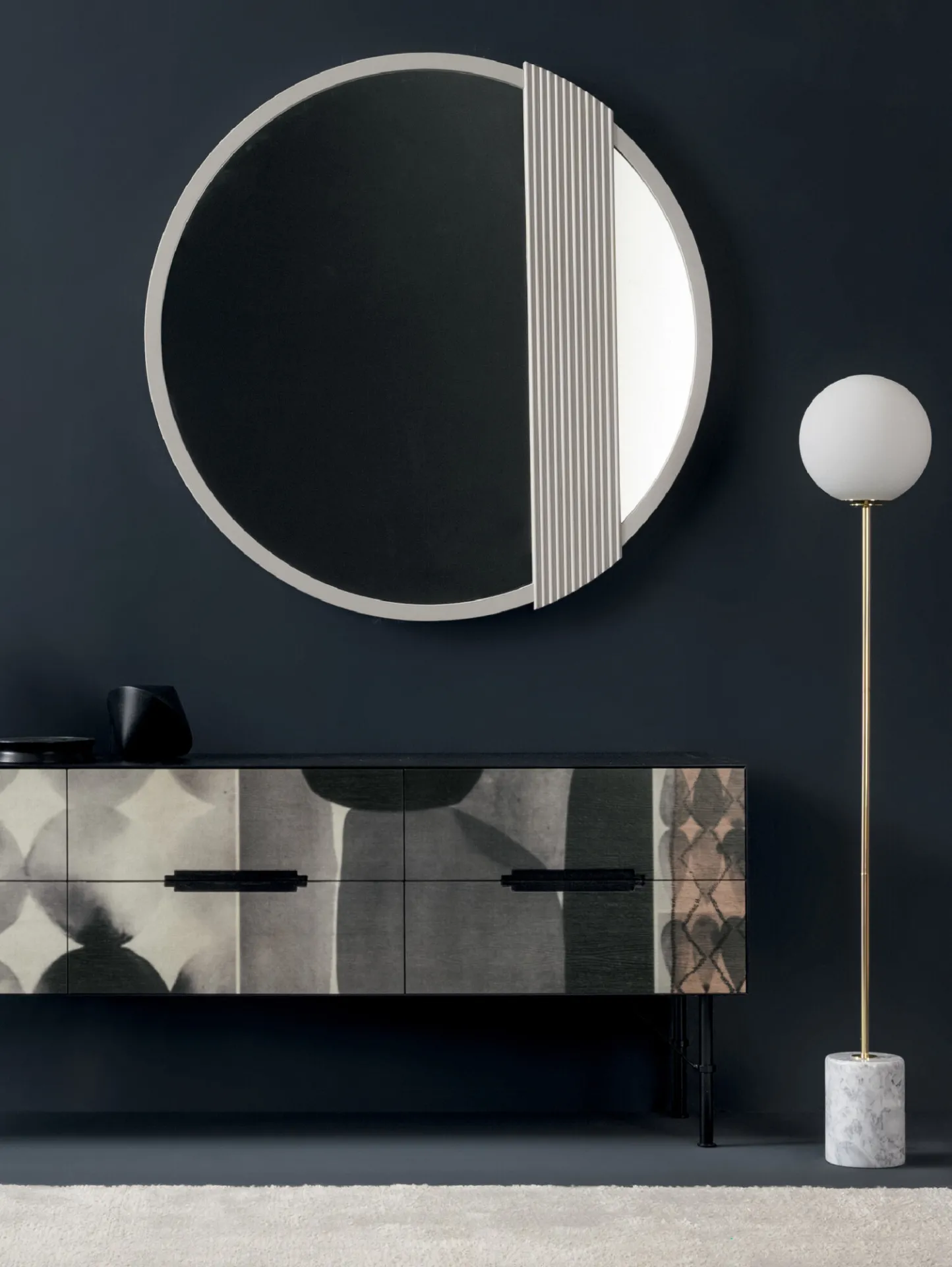 Madia .102 Devina Nais con decoro geometrico sotto uno specchio rotondo, su parete blu scuro