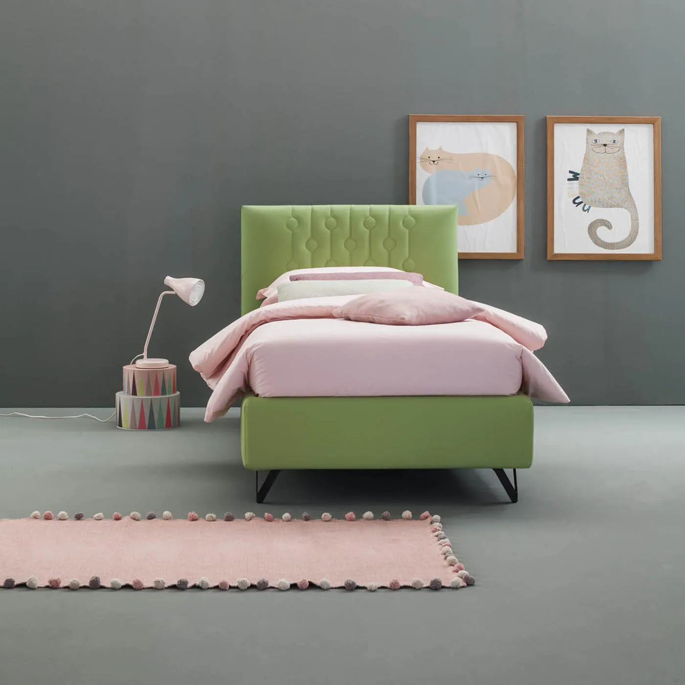 Letto singolo Loop Samoa verde su gambe in metallo nero, sotto due quadri con animali