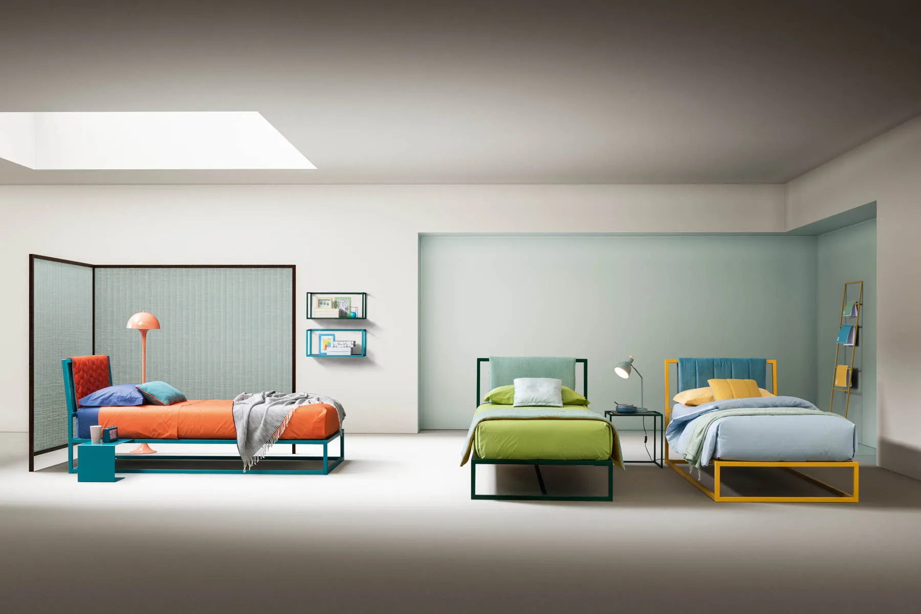 Tre letti singoli Frame Samoa con telai in metallo di colori diversi, in una cameretta luminosa