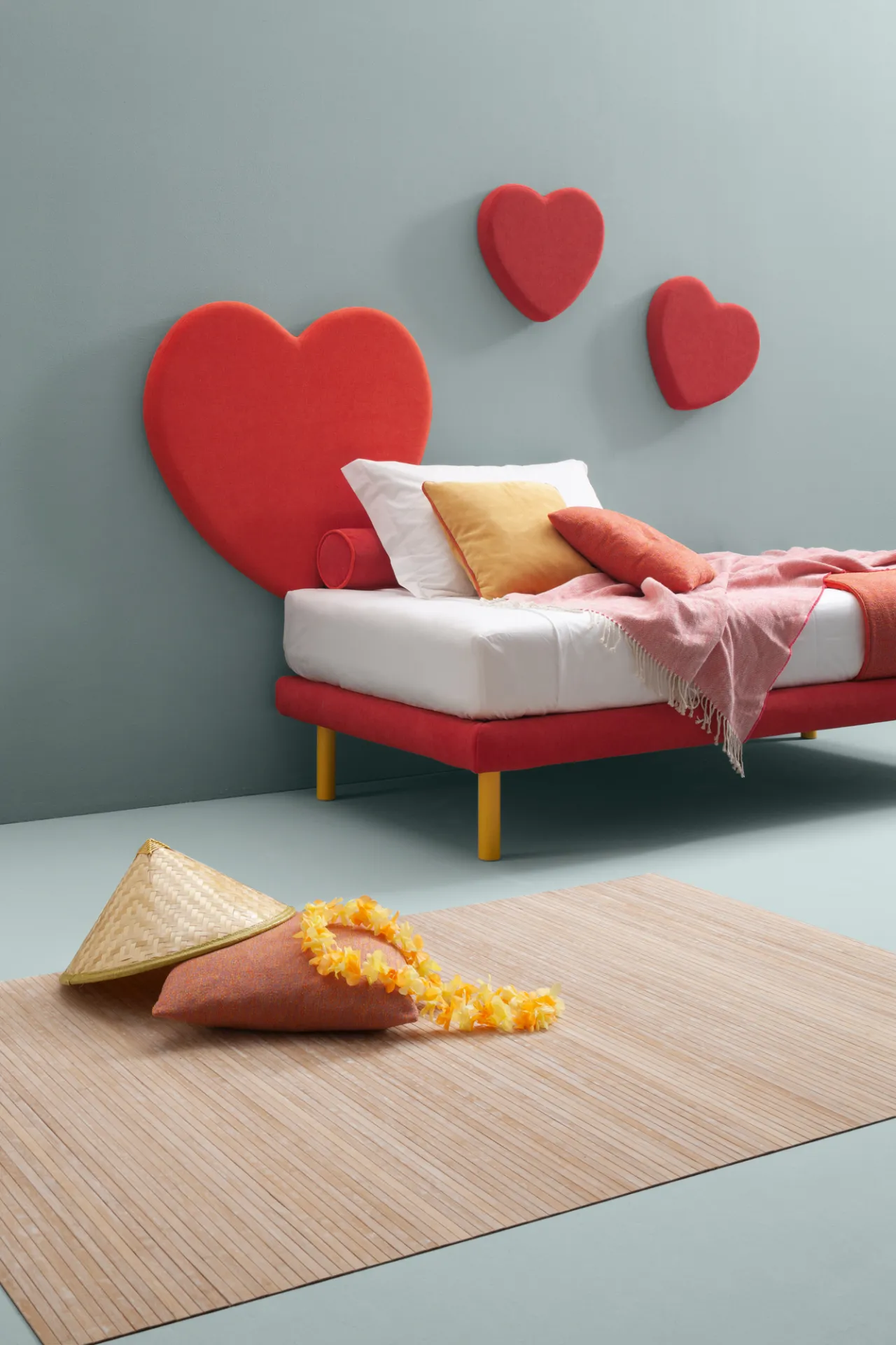 Grande cuore rosso Sweet Samoa usato come testiera di un letto bianco su piedini dorati