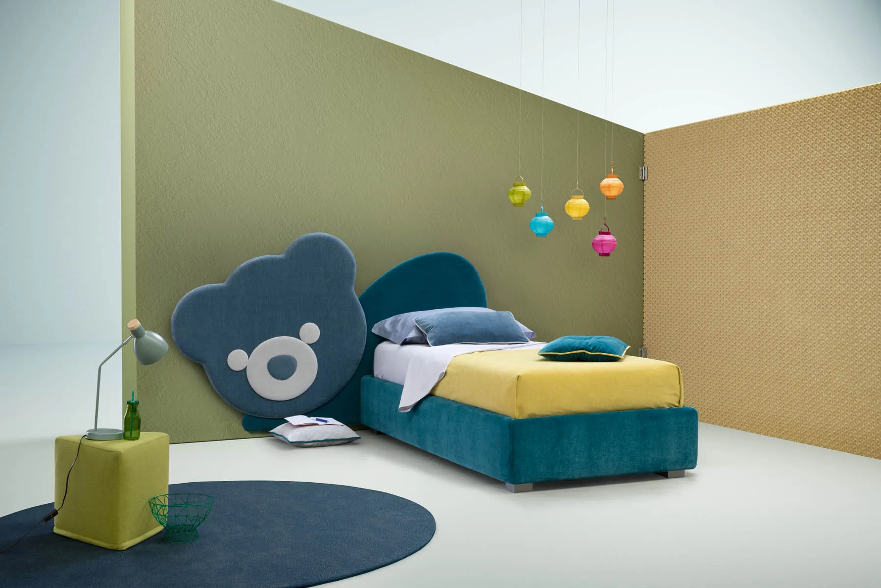 Pannello Ted Samoa a orsetto blu come testiera di un letto singolo ottanio, in una cameretta
