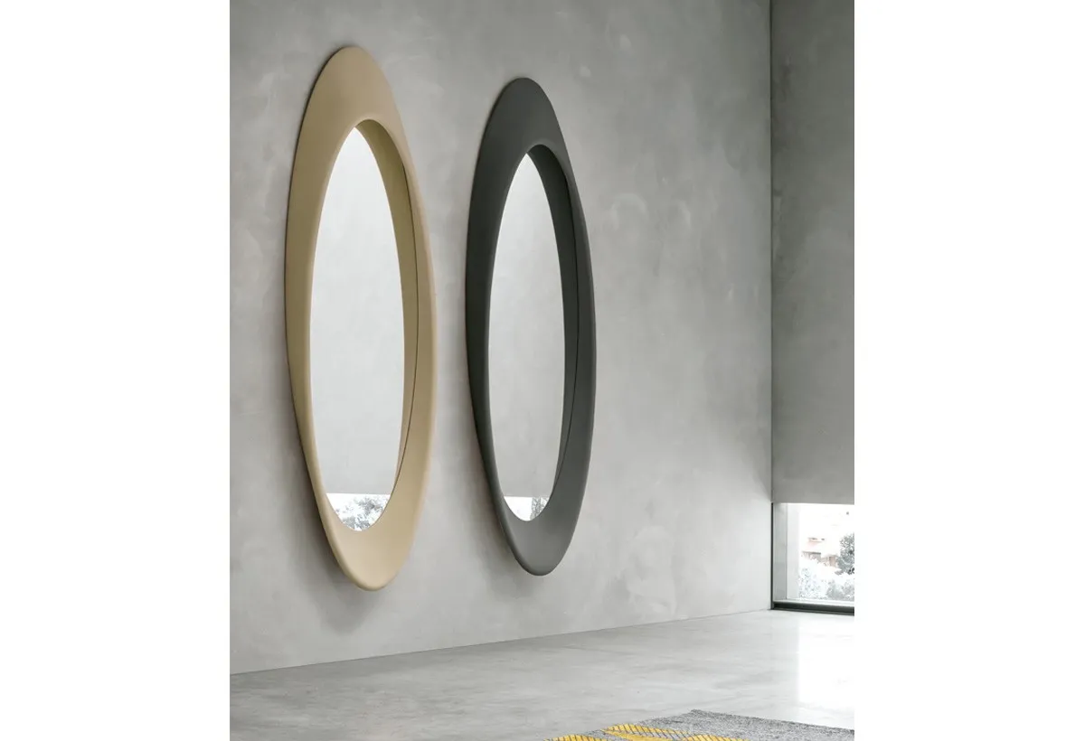 Due specchiere ovali Pleasure Target Point oro e grafite su una parete grigia