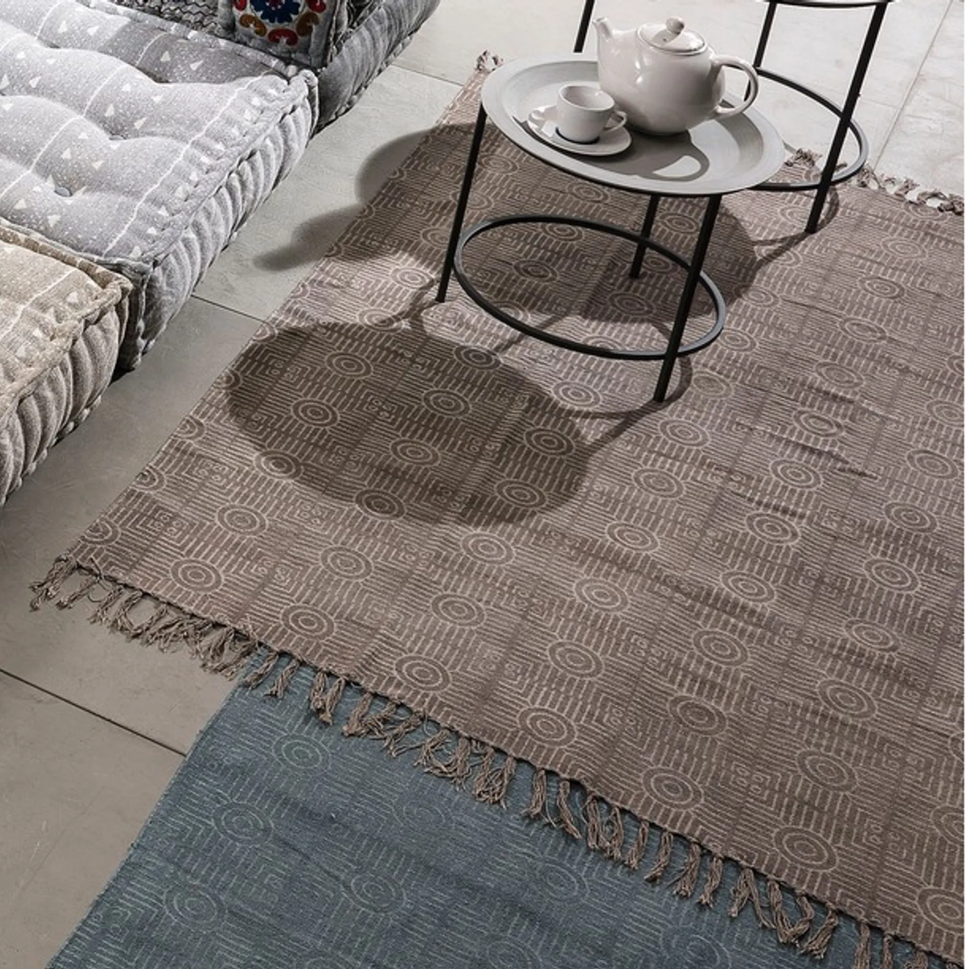 Tappeto Yara Tomasucci in cotone con nappe sotto un tavolino in metallo