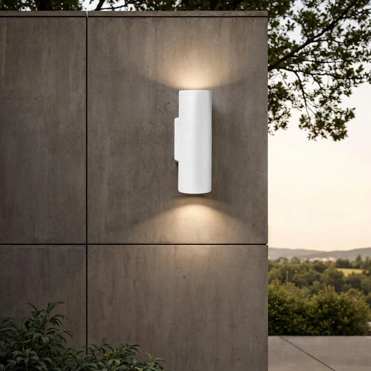 Applique Domus-B Outdoor Tomasucci in cemento bianco accesa su una parete esterna