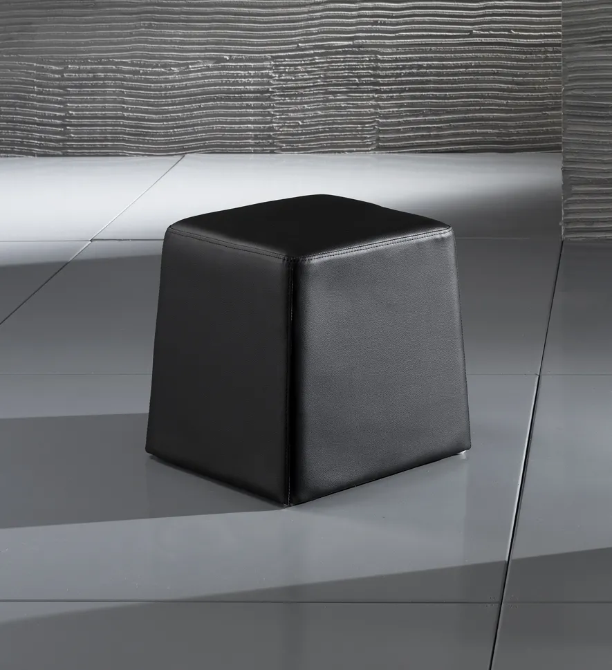 Pouf Key Black Tomasucci in pelle sintetica nera su un pavimento grigio