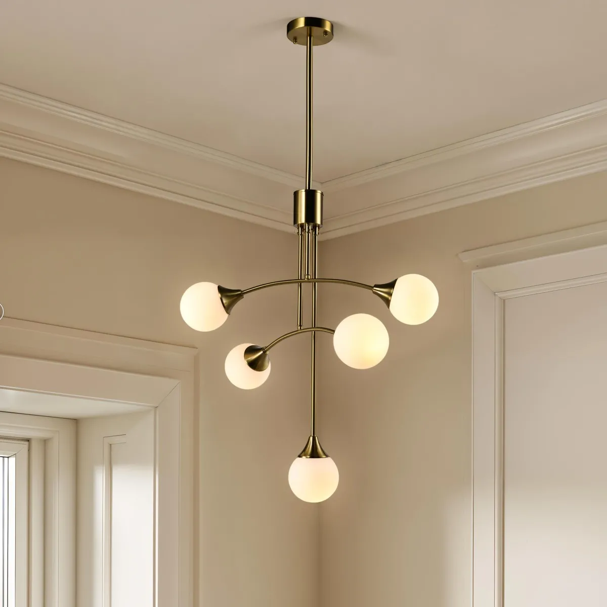 Lampadario Venice Tomasucci in ottone anticato con cinque sfere acceso in una stanza