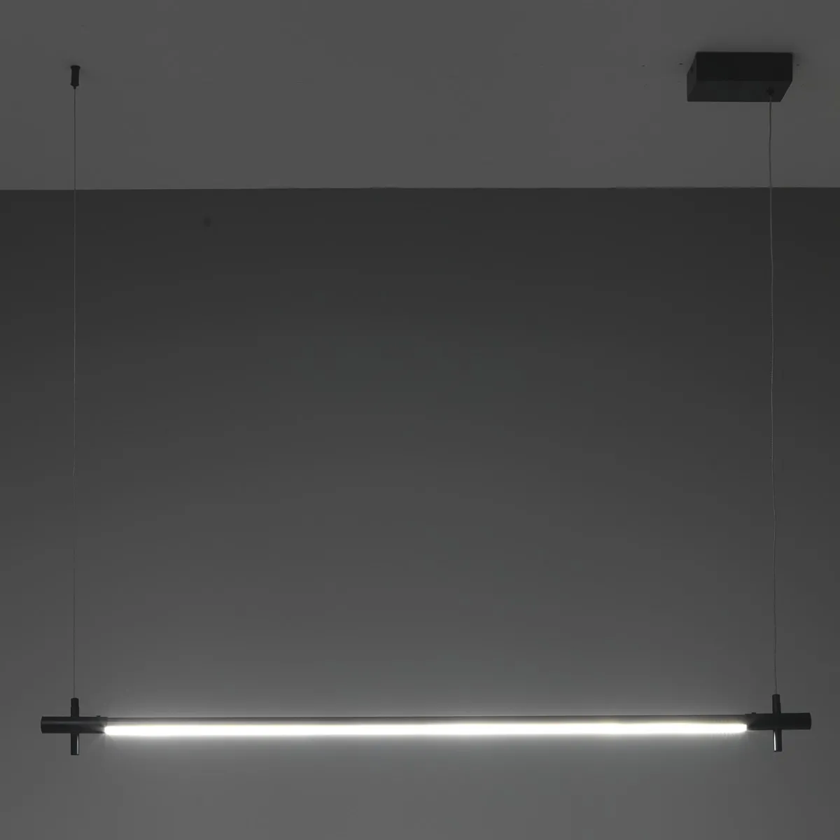 Lampadario slim Tomasucci acceso su fondo scuro