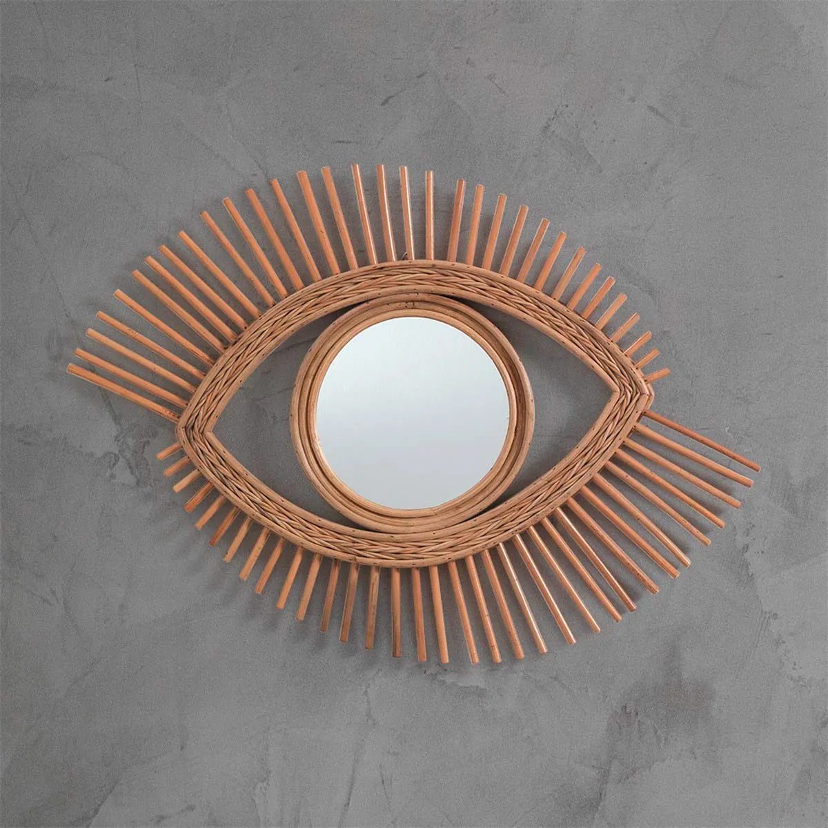Specchio a occhio Moti Tomasucci in rattan su parete grigia