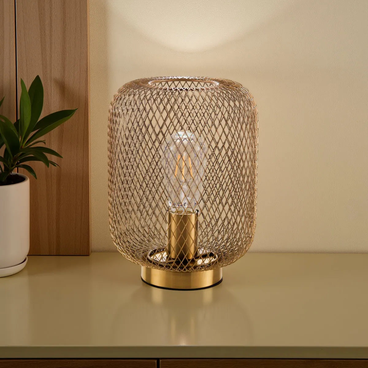Lampada Crate Tomasucci in ottone anticato su un mobile