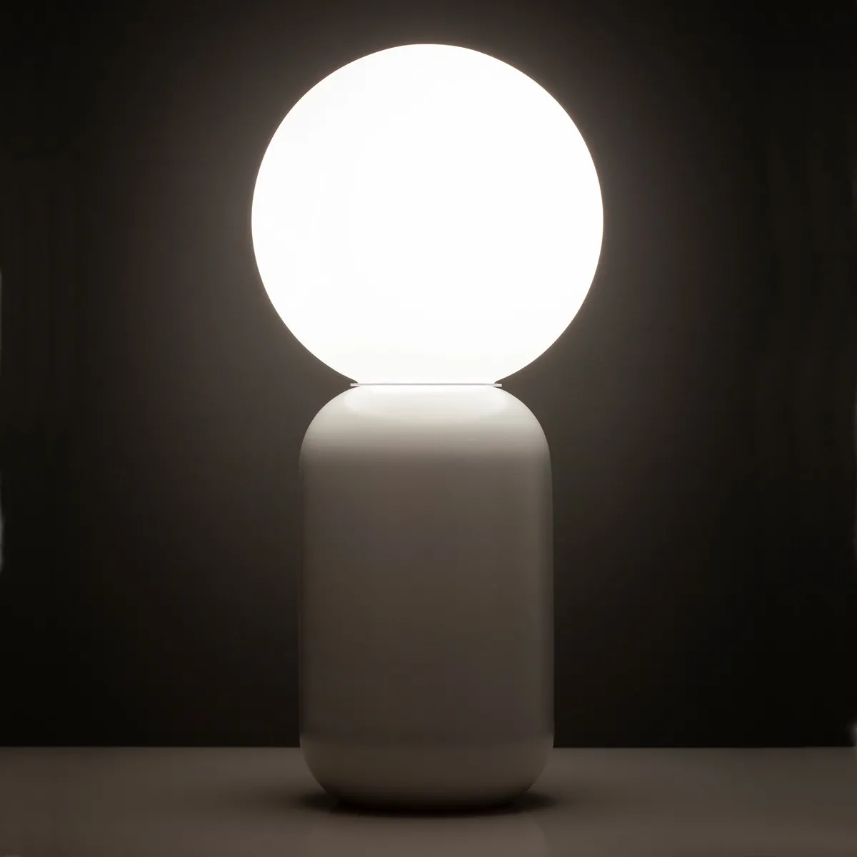Lampada da tavolo Clip Tomasucci accesa su fondo scuro