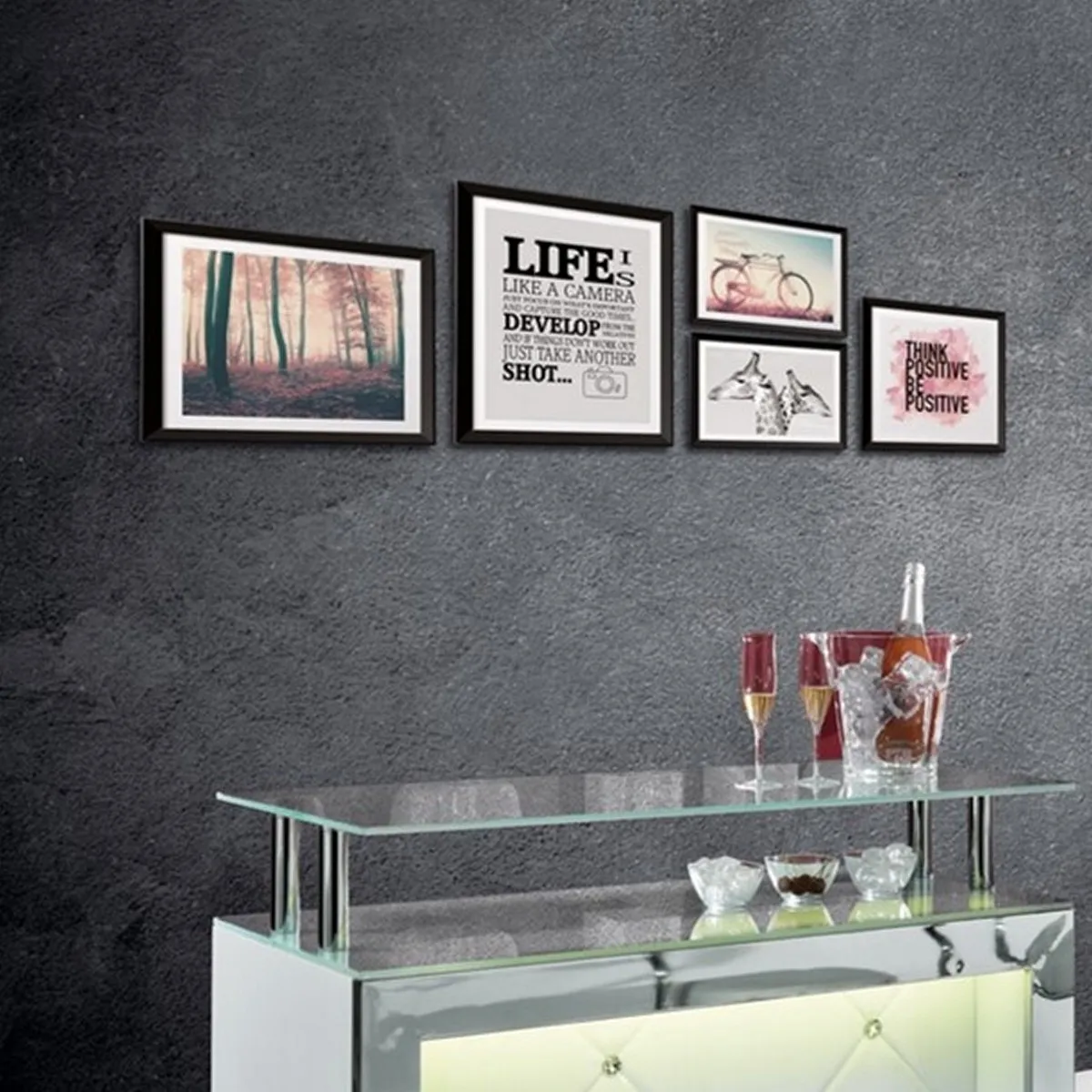 Composizione di quadri Life Tomasucci sopra un mobile