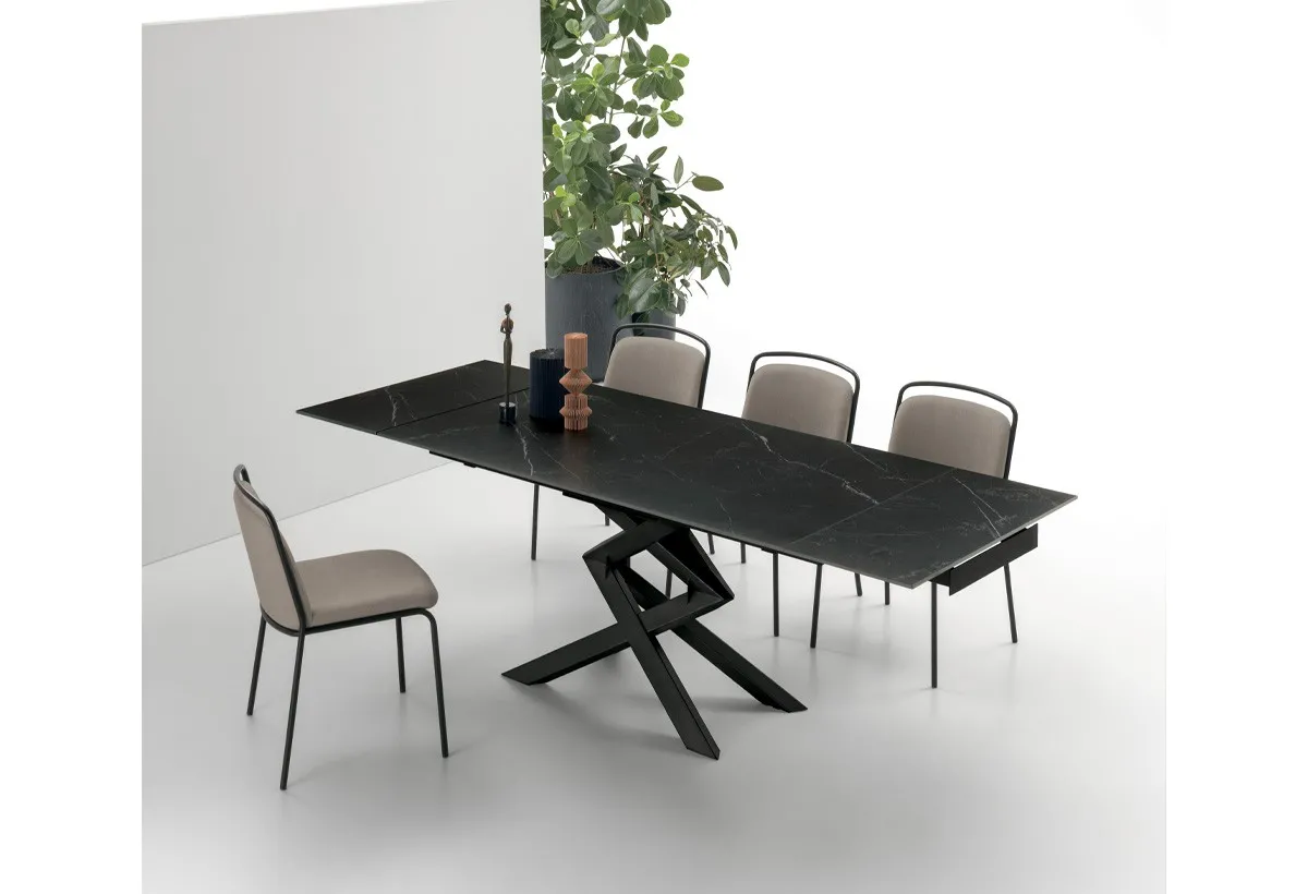 Tavolo Cross Target Point scuro con sedie beige fra le piante