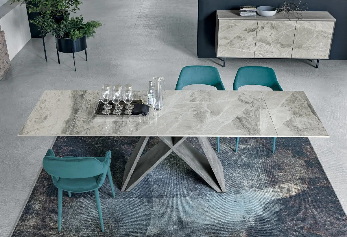 Tavolo Delta Target Point con piano effetto marmo e sedie verde acqua su un tappeto