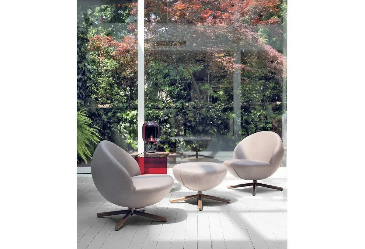 Poltroncine Vovo Target Point con pouf davanti a una vetrata sul giardino