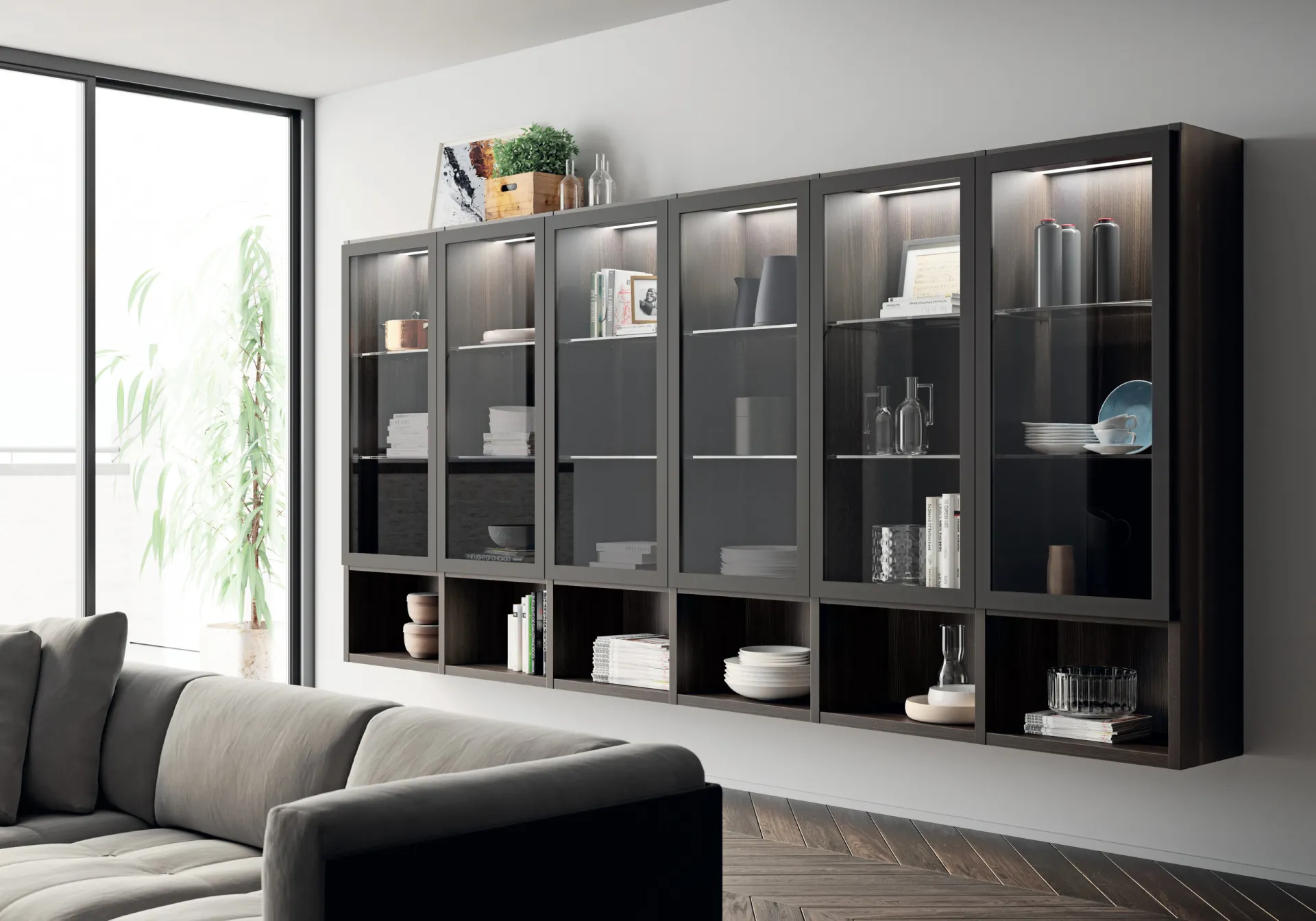 Soggiorno Carattere Scavolini con parete di vetrine scure illuminate sopra il divano