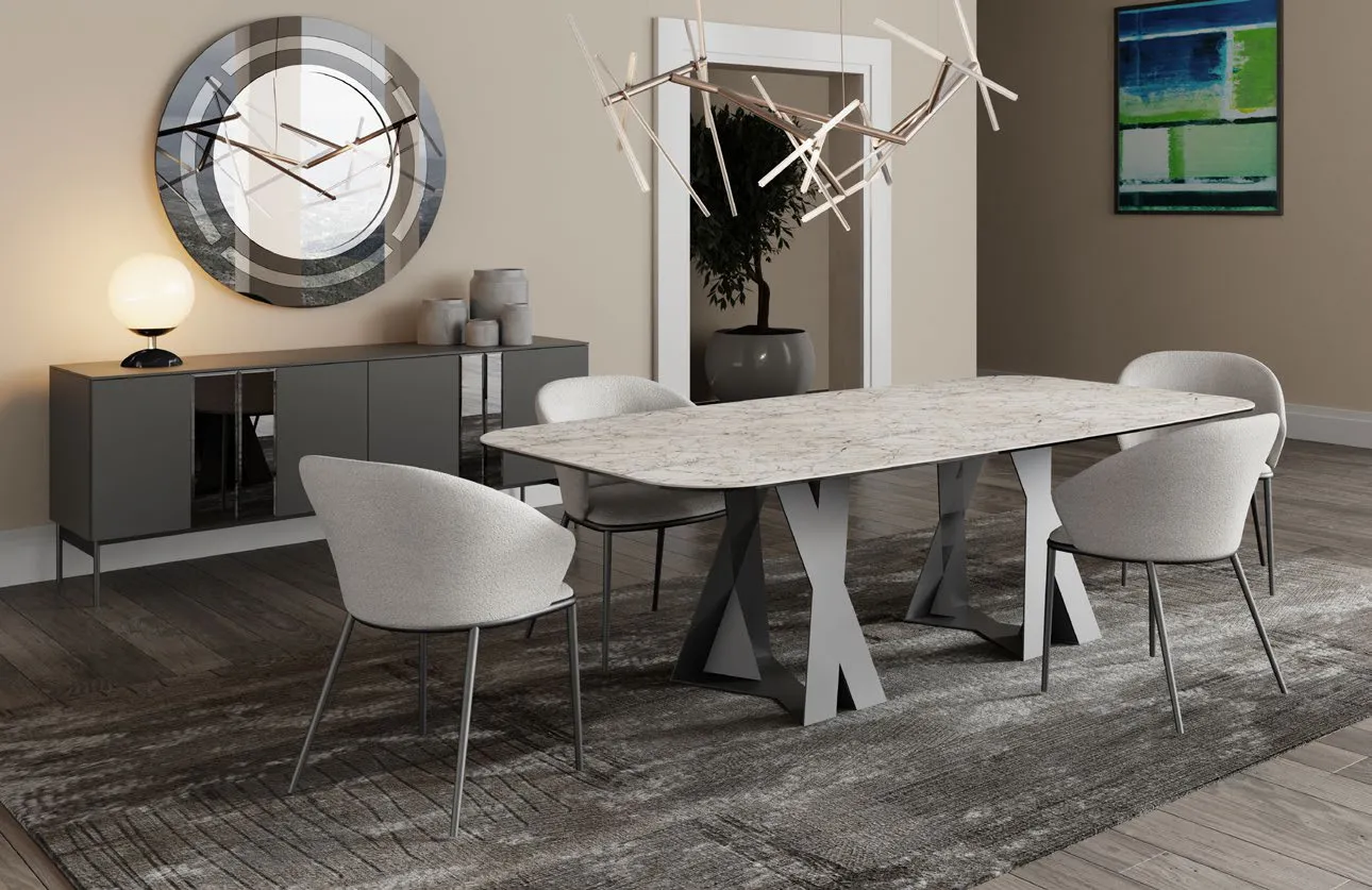 Tavolo Francis Zamagna Temptation con piano bianco e sedie chiare sotto un orologio