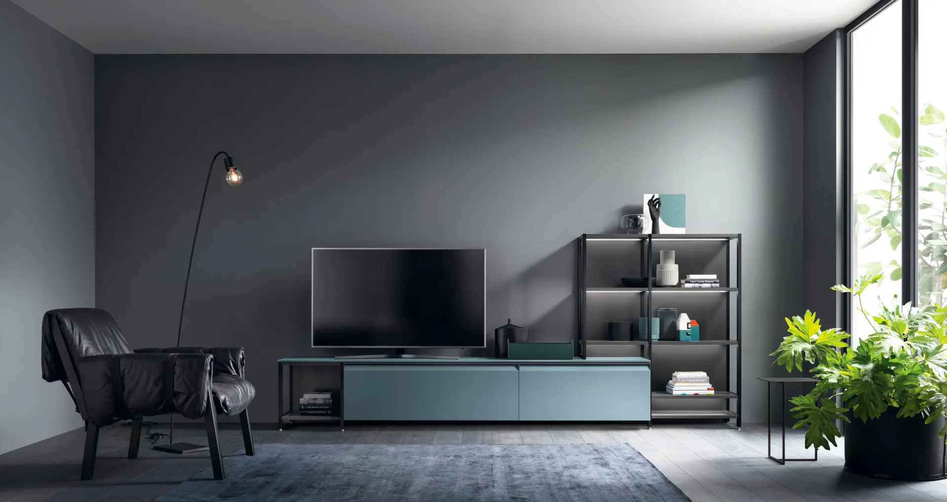 Soggiorno Formalia Scavolini con basi Verde Ottanio e libreria Sistema Parete Status nera illuminata