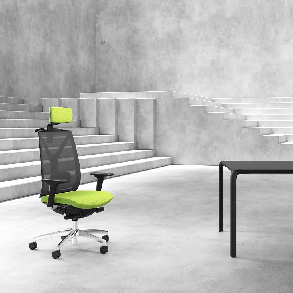 Sedia ergonomica Velia Unisit con poggiatesta davanti a una scala in cemento