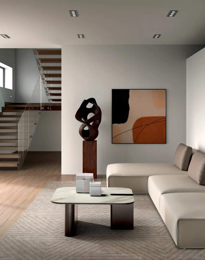 Tavolino Lock Stones Calacatta oro con struttura bronzo in un soggiorno con scala a vista