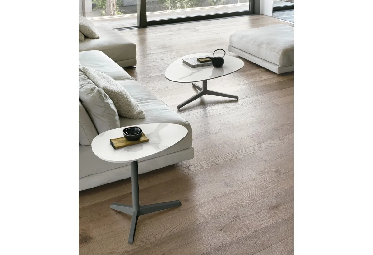 Tavolini Elica Target Point bianco e nero davanti a un divano chiaro su parquet