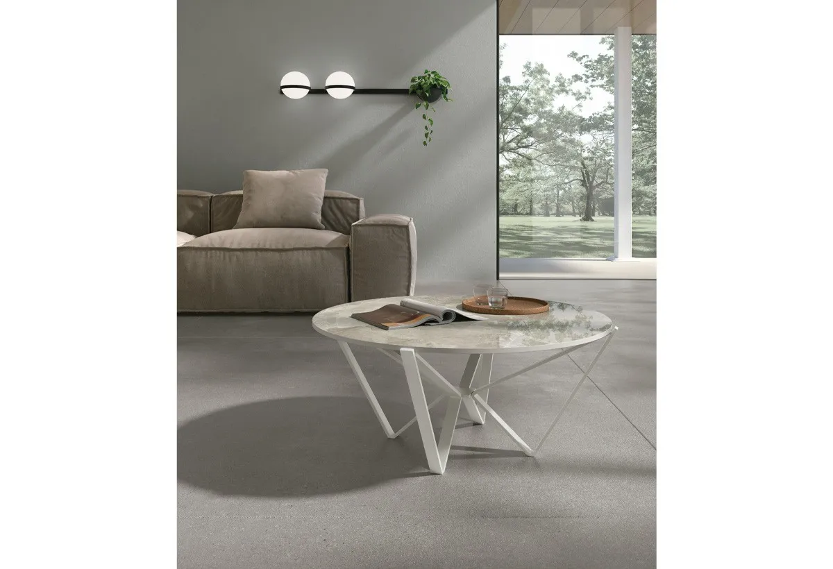 Tavolino Spider Target Point bianco con piano effetto marmo accanto a un divano grigio