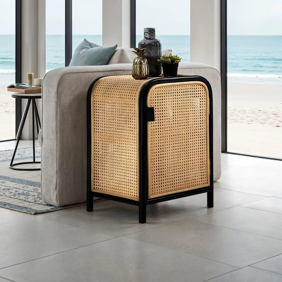 Armadietto Hamsa Tomasucci in teak e rattan accanto a un divano