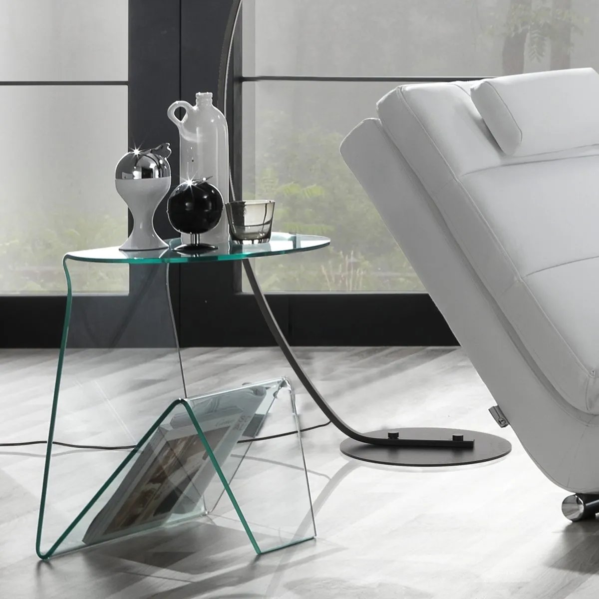 Tavolino Mark Tomasucci in vetro curvato accanto a una chaise longue