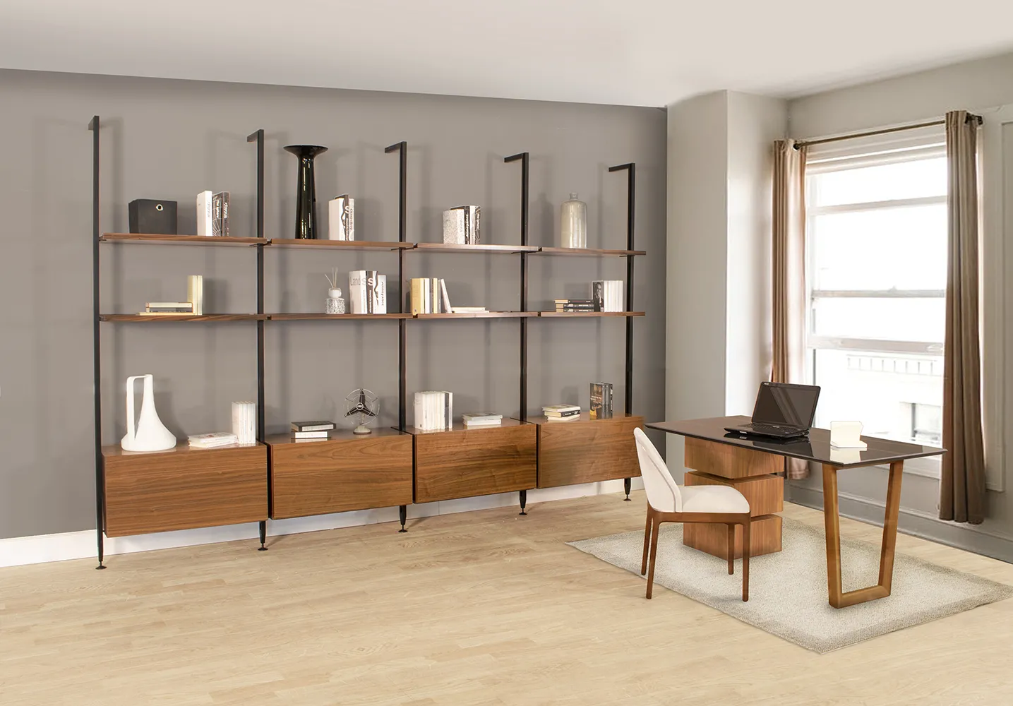 Libreria Tosato 60.40 con montanti neri e ripiani in noce canaletto lungo la parete di uno studio luminoso