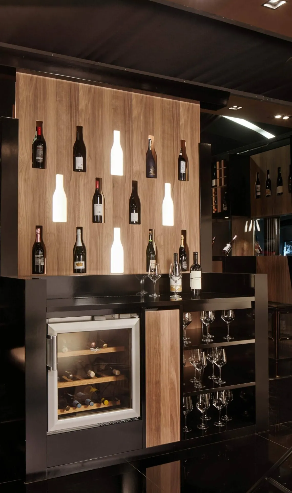 Parete portabottiglie Tosato 70.09 in noce canaletto con nicchie illuminate e base nera con cantinetta