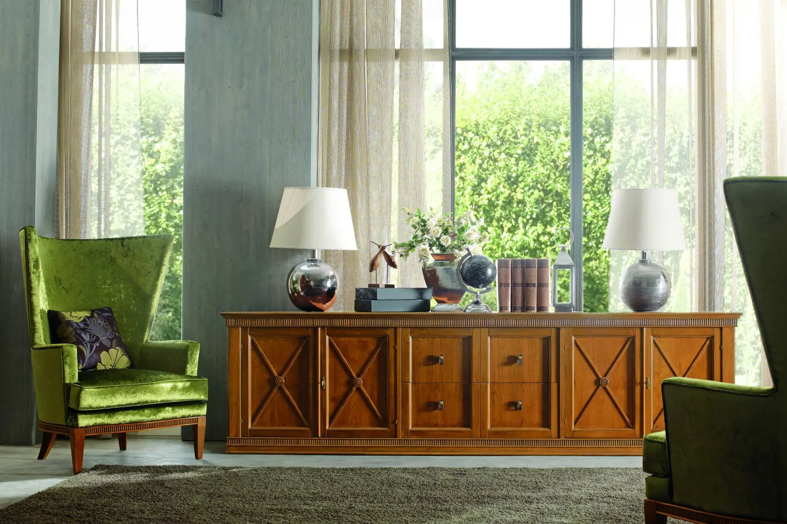 Credenza da studio Tosato 60.24 in noce con ante a croce, fra due poltrone verdi davanti a una vetrata