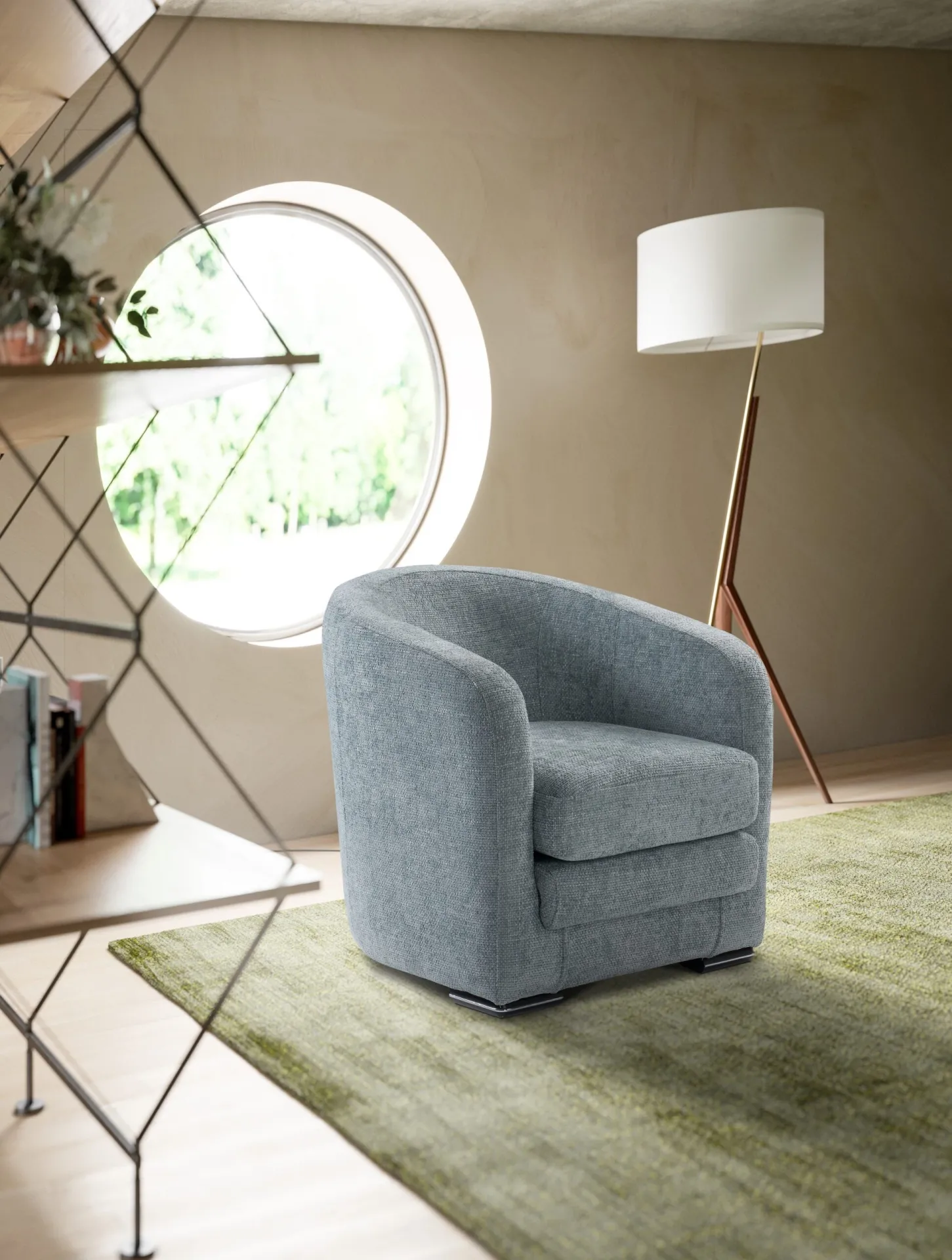 Poltroncina Kelly Il Benessere azzurra accanto a una finestra tonda