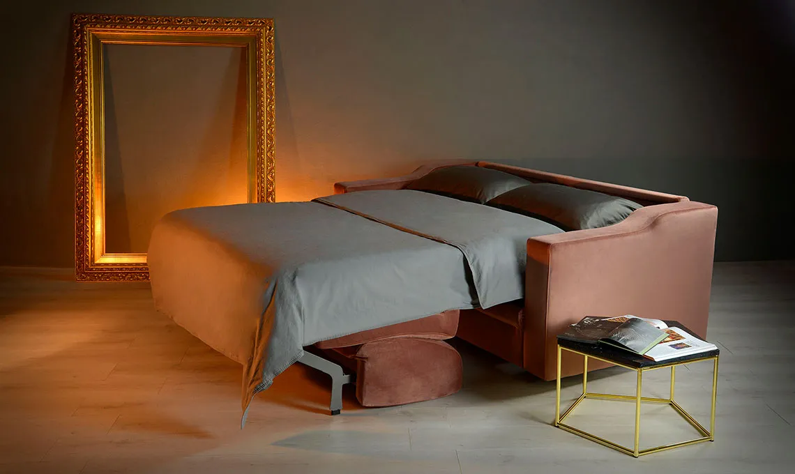 Divano letto Elektra Domingo aperto, con lenzuola grigie e cornice dorata alle spalle