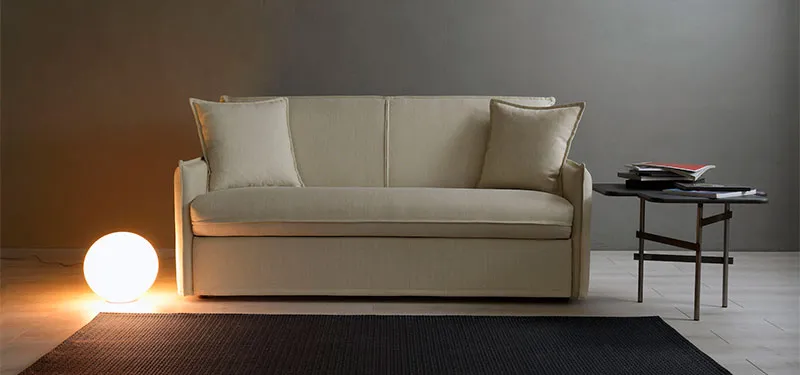 Divano letto Atena Domingo color crema in un soggiorno con lampada a sfera