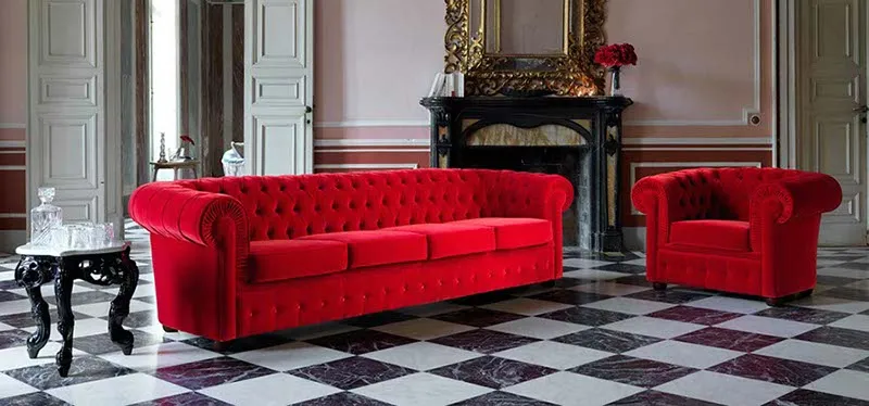 Divano classico 800 Domingo rosso con poltrone in un salotto a scacchi