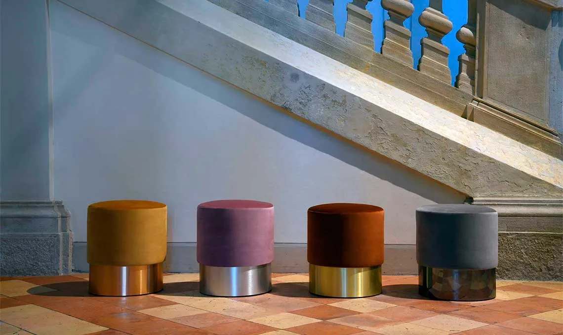 Pouf Chione Domingo colorati su basi metalliche ai piedi di una scala