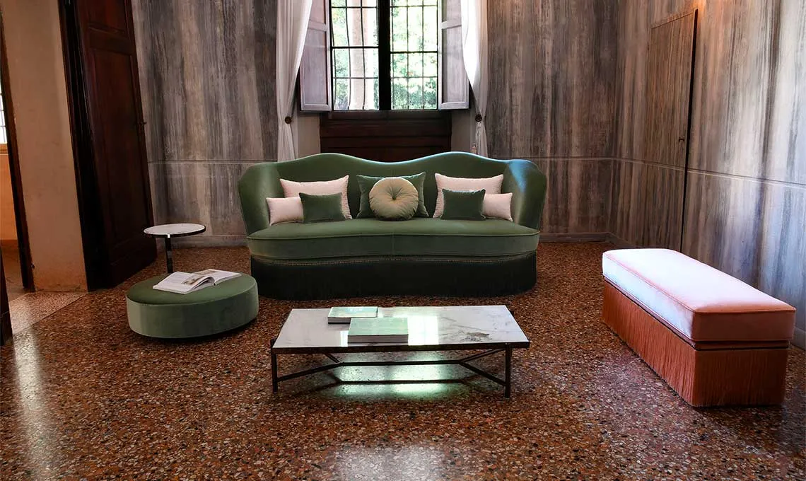 Poltroncine e pouf Dione Domingo in un salone con lampadario