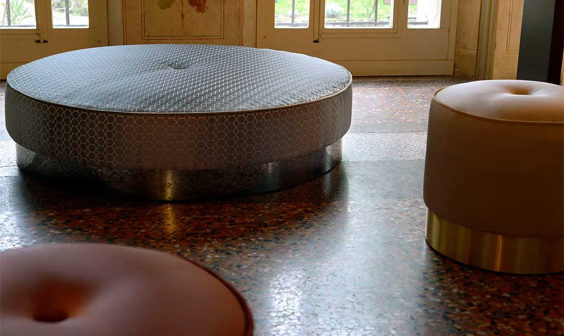 Pouf Eos Domingo rotondo grande con piping in un salone