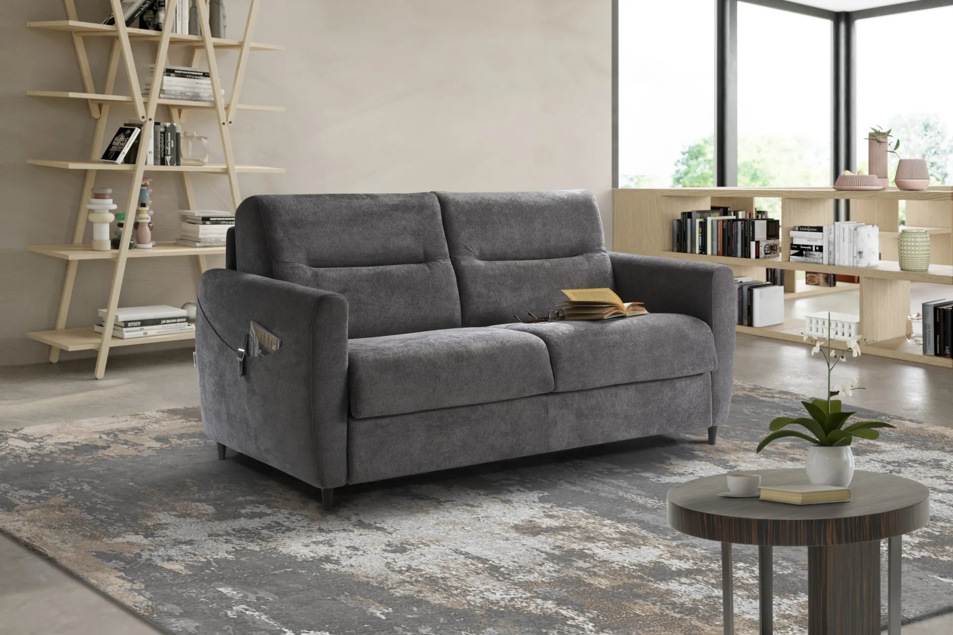 Divano letto Roger Il Benessere grigio scuro in un soggiorno con libreria