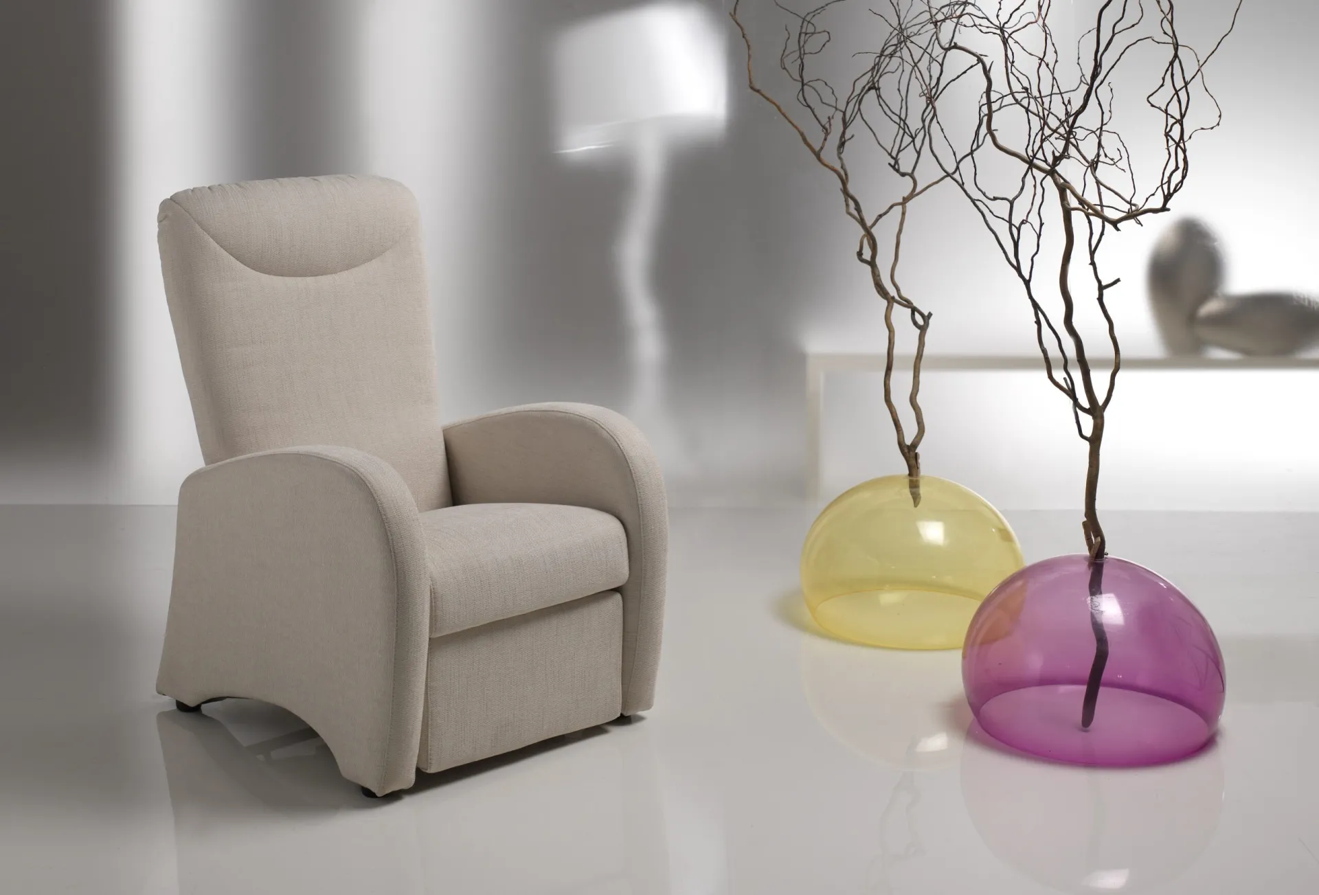 Poltrona relax manuale Touring Il Benessere beige accanto a vasi colorati