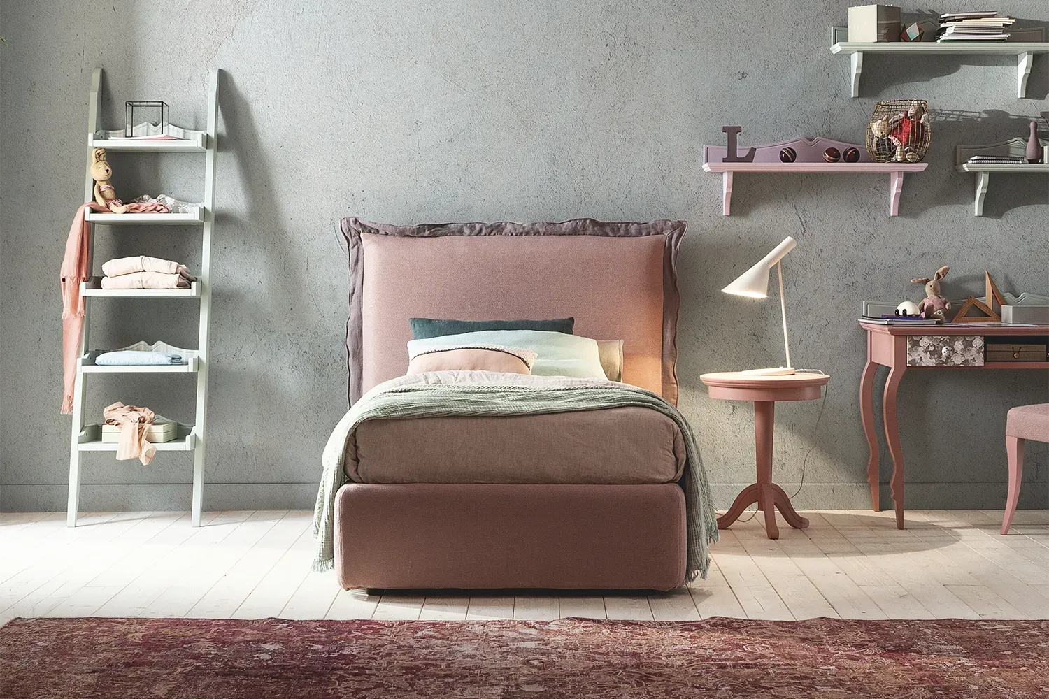 Letto Morfeo Callesella singolo rivestito in rosa in una cameretta con libreria a scala